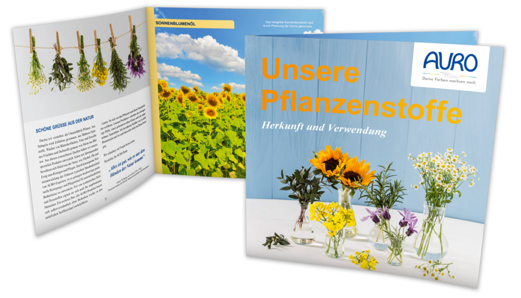 Eine Rohstoff-Broschüre von AURO Naturfarben mit der Aufschrift ‚Unsere Pflanzenstoffe’ und einigen Blumen in Vasen auf einem runden Tisch